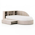Beige bed with rounded base and side drawers by Fingerjointfurniture, showcasing a modern design and storage features.